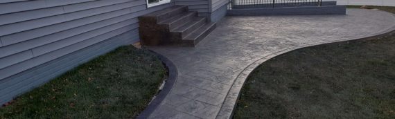 A stunning concrete backyard patio and staircase installation in Odenton, MD